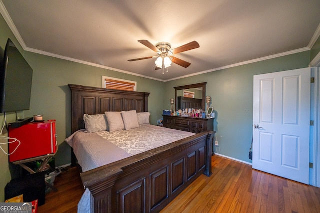 bedroom featuring hardwood / wood-style floors, crown molding, and ceiling fan