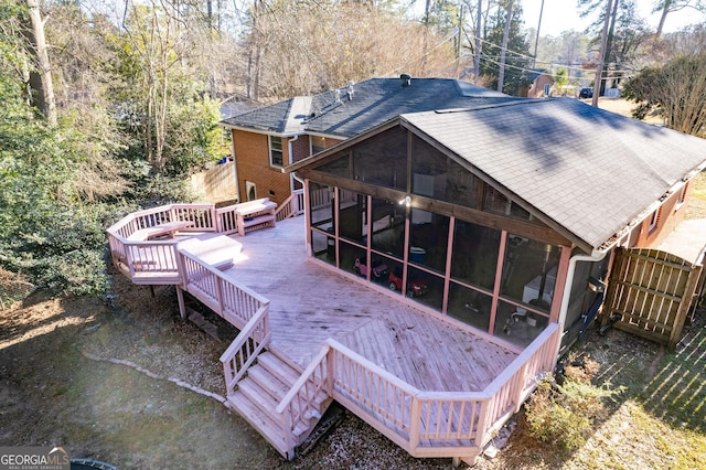 back of house featuring a wooden deck and a sunroom