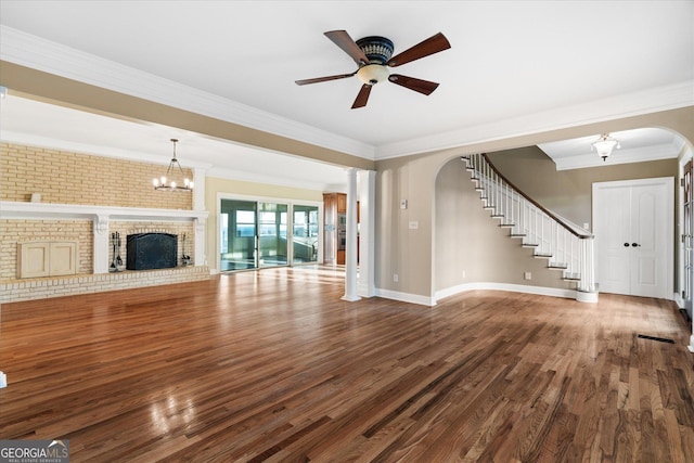 unfurnished living room with arched walkways, wood finished floors, a fireplace, and stairs