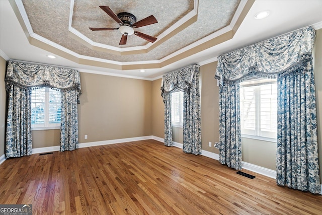 unfurnished room featuring a raised ceiling and crown molding