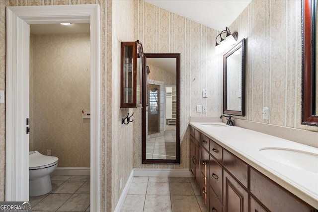 bathroom featuring tile patterned floors, a sink, toilet, and wallpapered walls