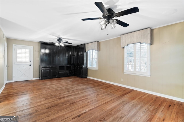 interior space featuring a wealth of natural light, baseboards, and wood finished floors