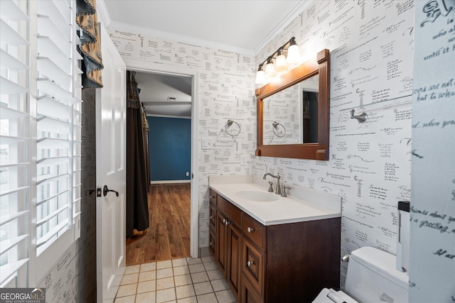 bathroom featuring wallpapered walls, toilet, ornamental molding, vanity, and tile patterned floors