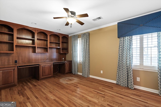 unfurnished office featuring a ceiling fan, visible vents, dark wood-style flooring, and built in study area