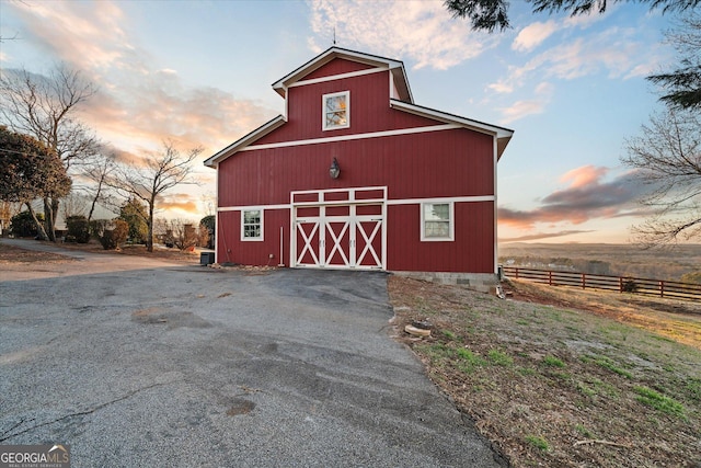 view of barn featuring fence