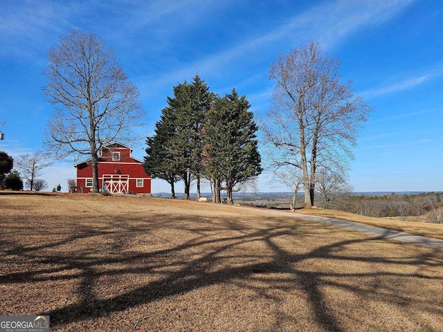 view of yard with an outbuilding and a rural view