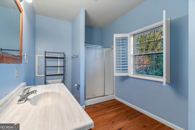 full bathroom with baseboards, toilet, wood finished floors, vanity, and a shower stall