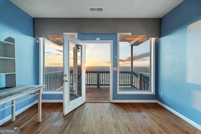 entryway featuring a healthy amount of sunlight, baseboards, visible vents, and wood finished floors