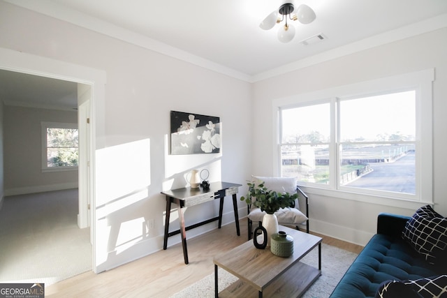 living room with crown molding, ceiling fan, and light wood-type flooring