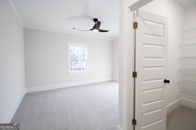 carpeted spare room featuring ornamental molding and ceiling fan