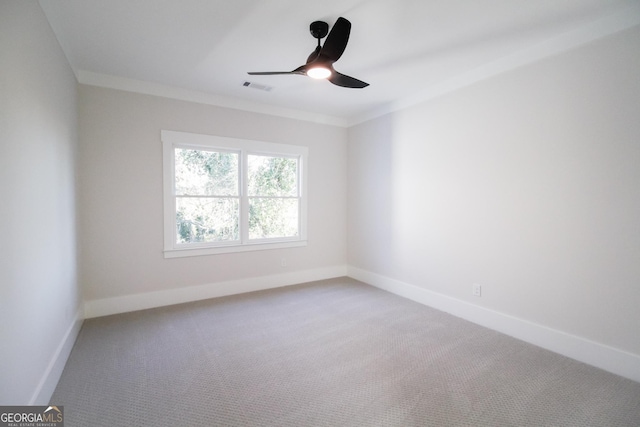 spare room featuring crown molding, carpet floors, and ceiling fan