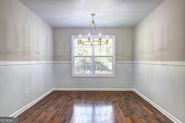 unfurnished dining area with a notable chandelier and dark hardwood / wood-style flooring