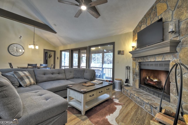 living room with vaulted ceiling with beams, hardwood / wood-style flooring, a fireplace, and ceiling fan