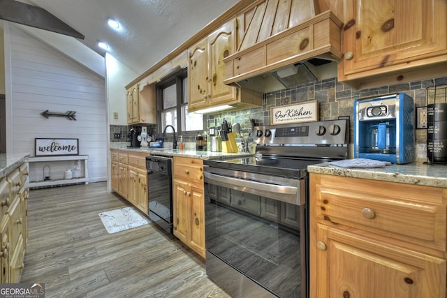 kitchen with black dishwasher, sink, stainless steel range with electric cooktop, light stone countertops, and custom range hood