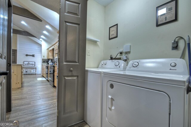 laundry room with washer and dryer and light wood-type flooring