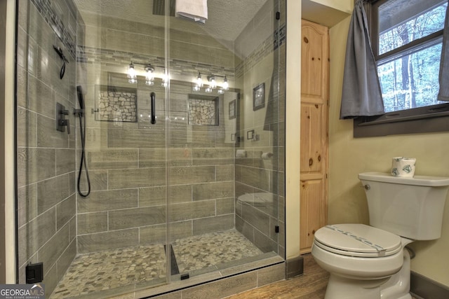 bathroom featuring toilet and an enclosed shower