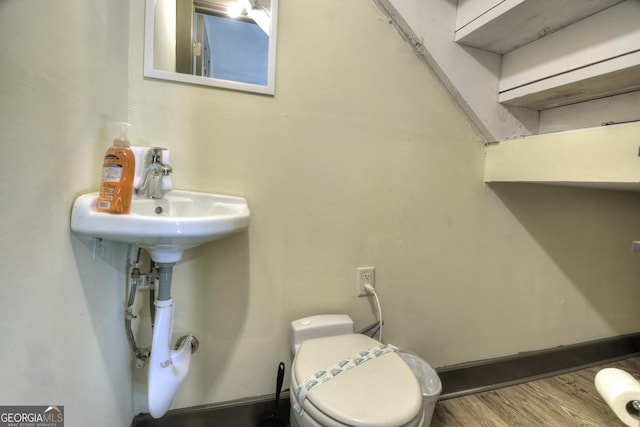 bathroom with hardwood / wood-style floors and toilet