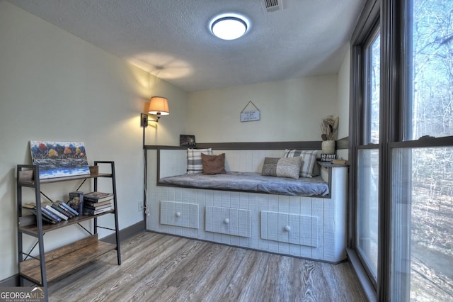 bedroom with hardwood / wood-style floors and a textured ceiling