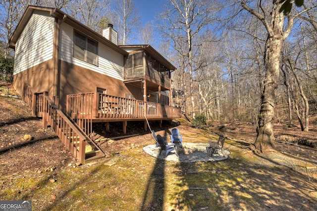 back of house with a sunroom and a deck