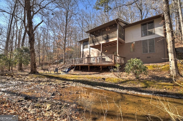 back of property with a balcony and a deck