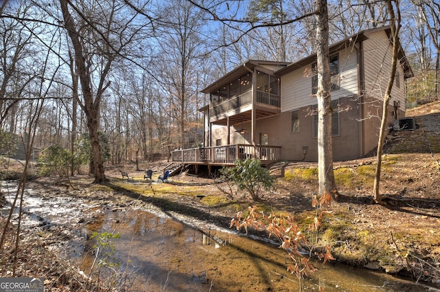 view of side of property featuring a wooden deck and a sunroom