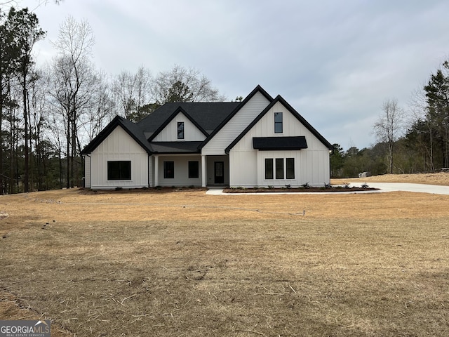 modern farmhouse style home with board and batten siding and a front yard