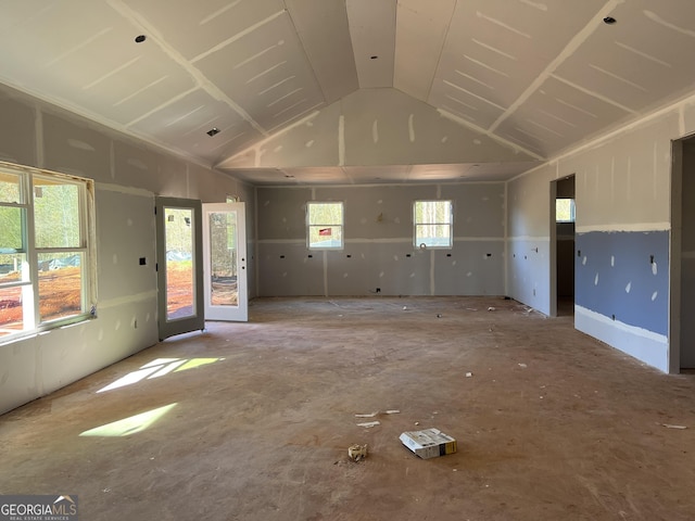 unfurnished living room featuring vaulted ceiling