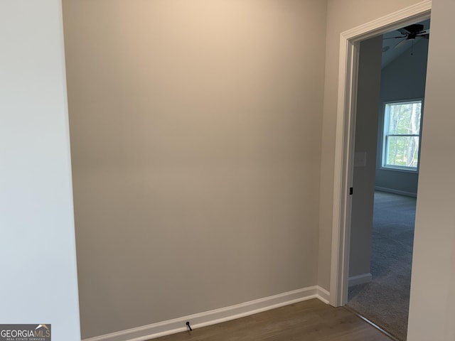empty room with baseboards, vaulted ceiling, ceiling fan, and dark wood-style floors