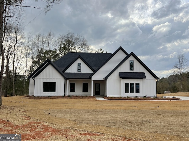 modern farmhouse featuring board and batten siding and roof with shingles