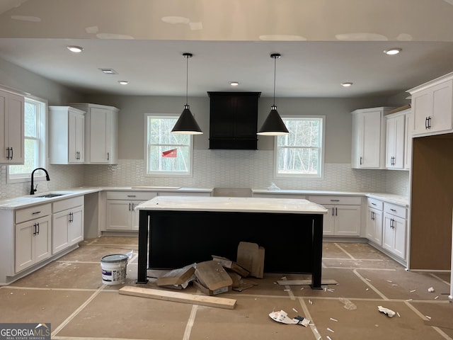 kitchen with a sink, white cabinetry, and decorative backsplash