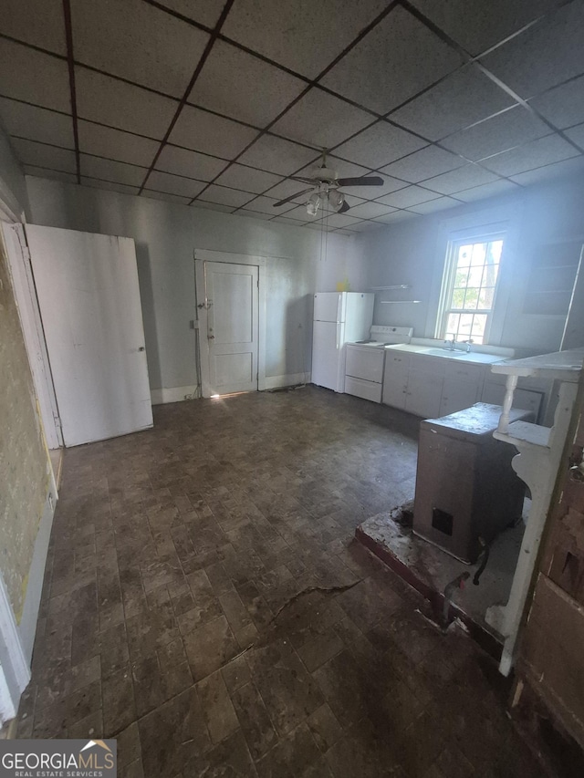 basement with ceiling fan and white fridge