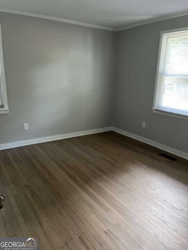 spare room with crown molding and hardwood / wood-style flooring