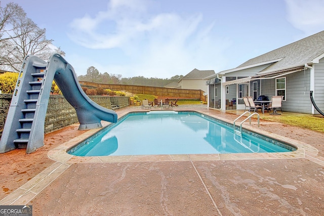 view of swimming pool featuring a patio and a water slide