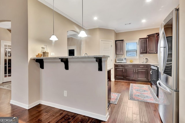 kitchen featuring a breakfast bar area, dark wood-type flooring, dark brown cabinets, stainless steel appliances, and decorative light fixtures