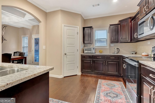 kitchen featuring dark brown cabinetry, coffered ceiling, appliances with stainless steel finishes, dark hardwood / wood-style flooring, and beamed ceiling