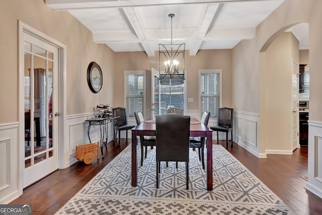 dining area featuring dark hardwood / wood-style floors, coffered ceiling, a notable chandelier, and beam ceiling