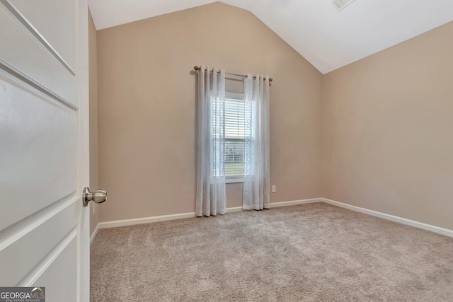 spare room with light carpet and vaulted ceiling