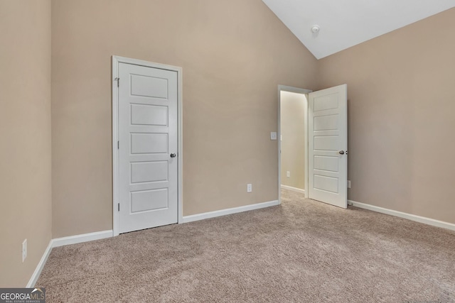 empty room with carpet flooring and high vaulted ceiling