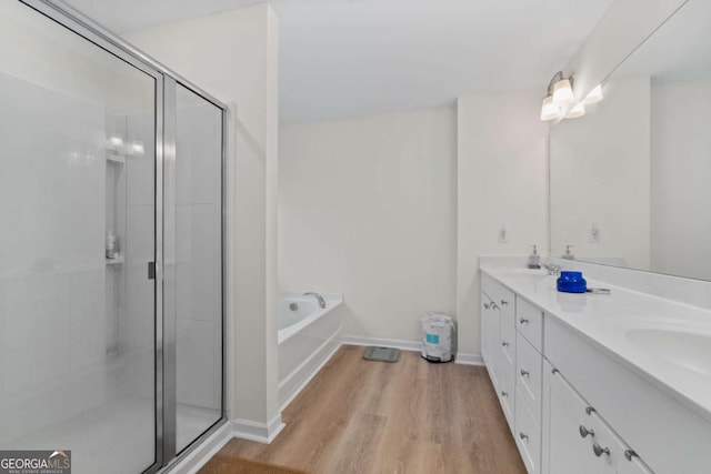 bathroom featuring hardwood / wood-style flooring, vanity, and independent shower and bath