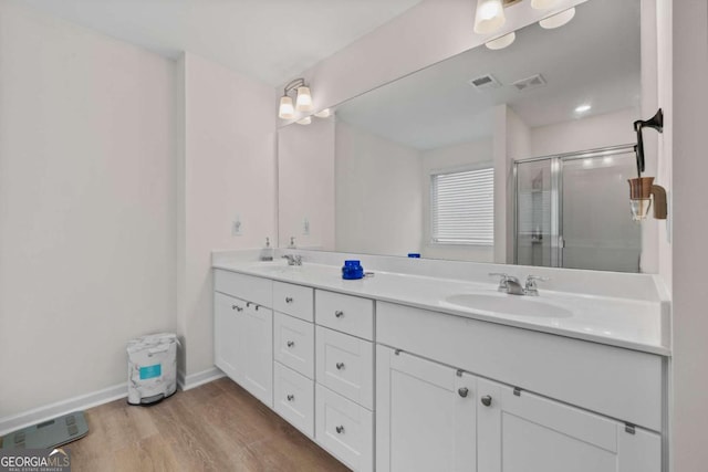 bathroom with vanity, hardwood / wood-style floors, and a shower with door