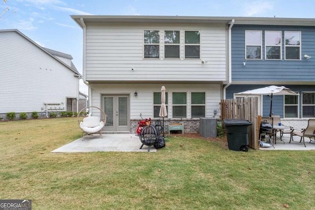 back of property with a patio, a fire pit, a yard, and french doors