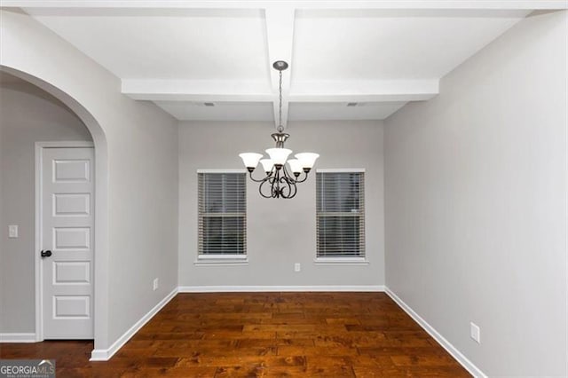 spare room with beamed ceiling, coffered ceiling, dark wood-type flooring, and a chandelier