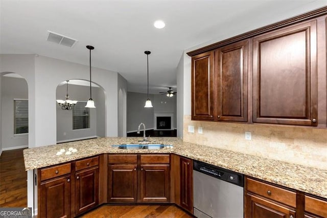 kitchen with stainless steel dishwasher, kitchen peninsula, sink, and hanging light fixtures