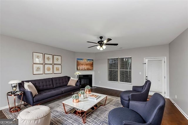 living room with dark wood-type flooring and ceiling fan