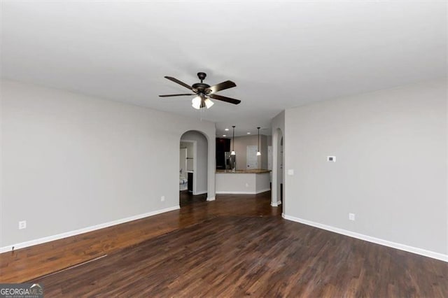 unfurnished living room with dark hardwood / wood-style floors and ceiling fan