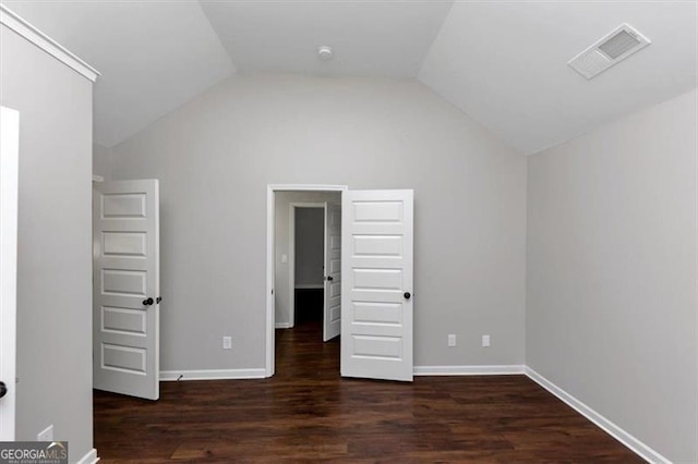 unfurnished bedroom with dark hardwood / wood-style floors and vaulted ceiling