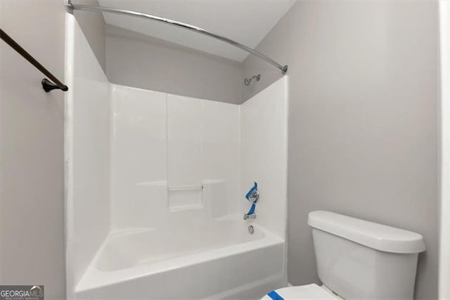 bathroom with shower / bathing tub combination and toilet