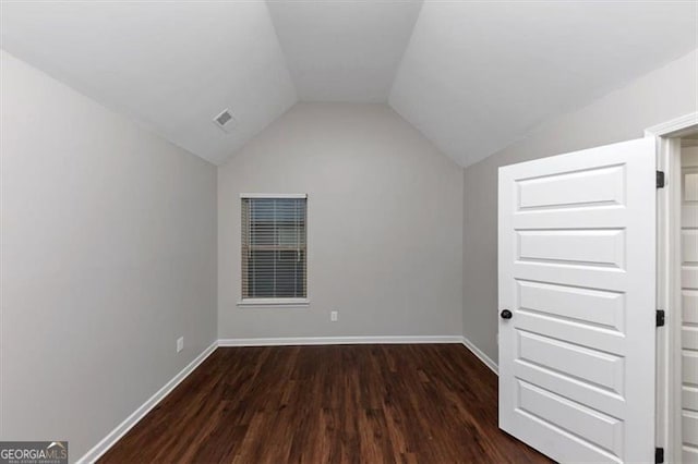 additional living space featuring dark wood-type flooring and vaulted ceiling