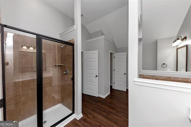 bathroom featuring wood-type flooring, an enclosed shower, and vaulted ceiling