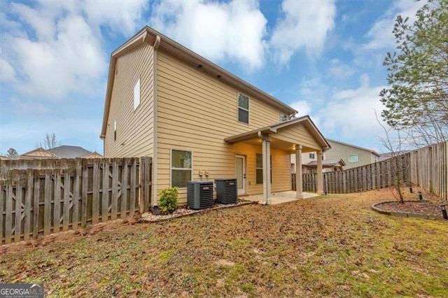 back of property featuring a lawn, a patio, and central air condition unit